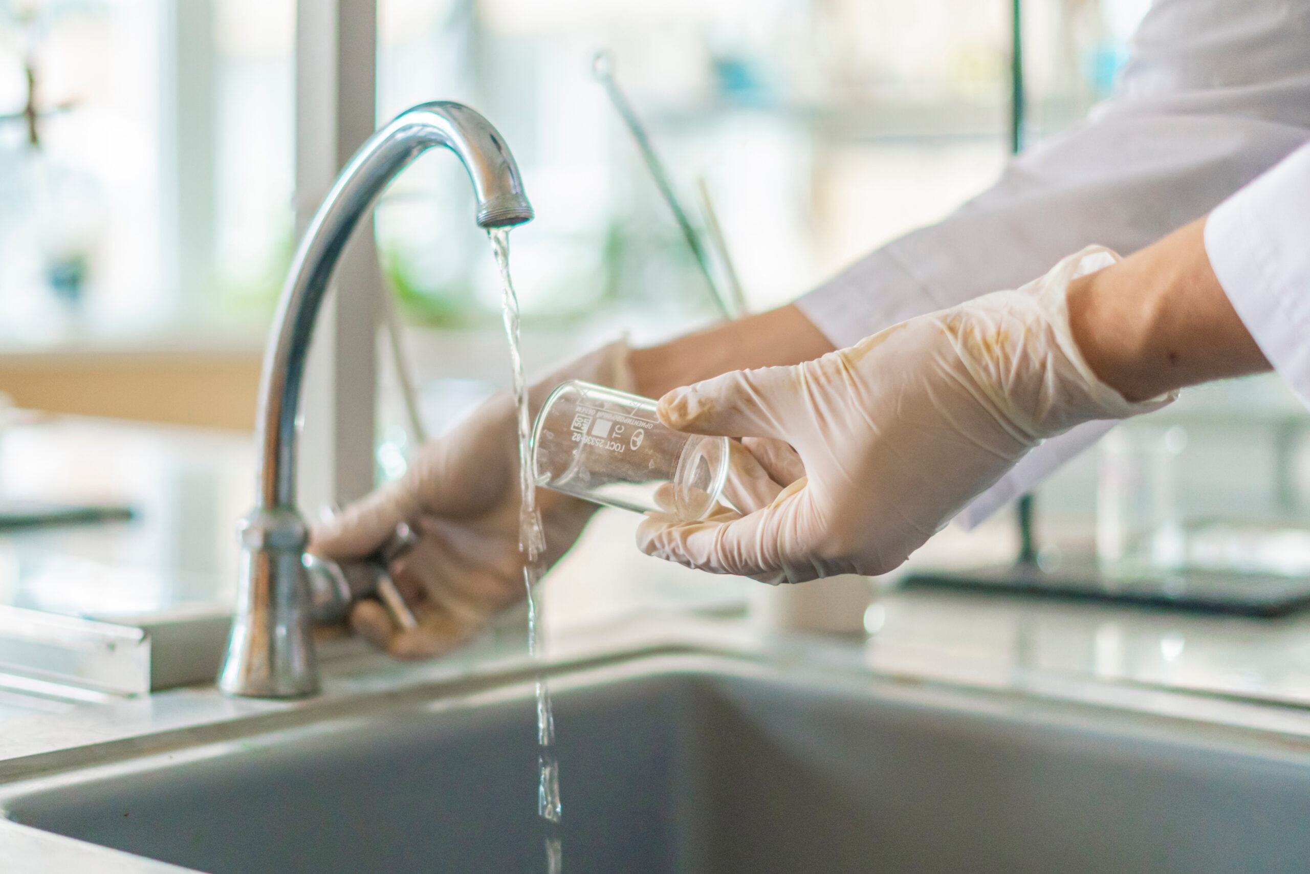 Treatment worker testing residential tap water for chemicals